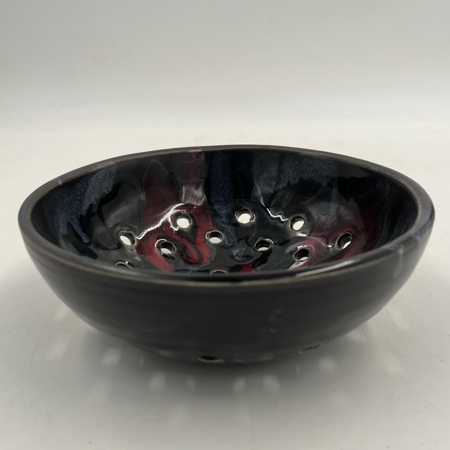 Black base produce collander on a white background