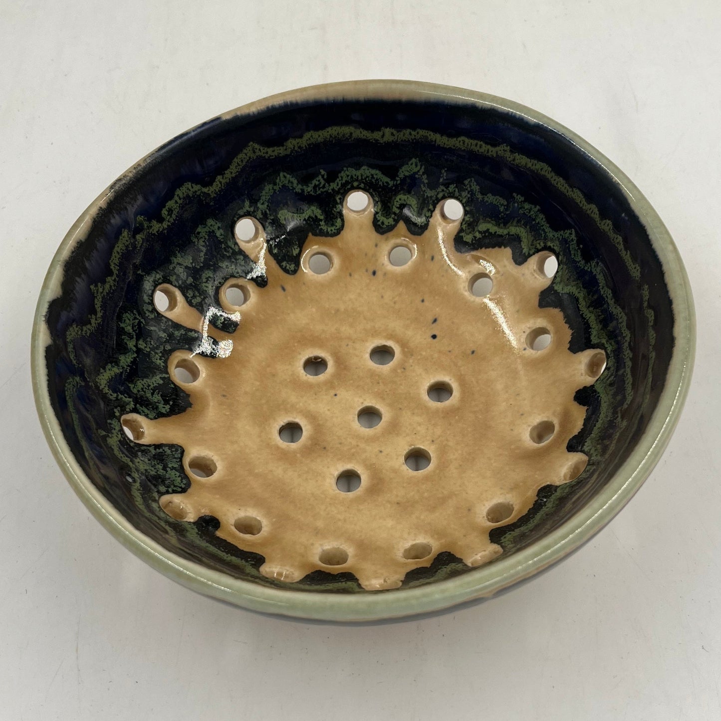 Round ceramic object with a textured surface on a white background
