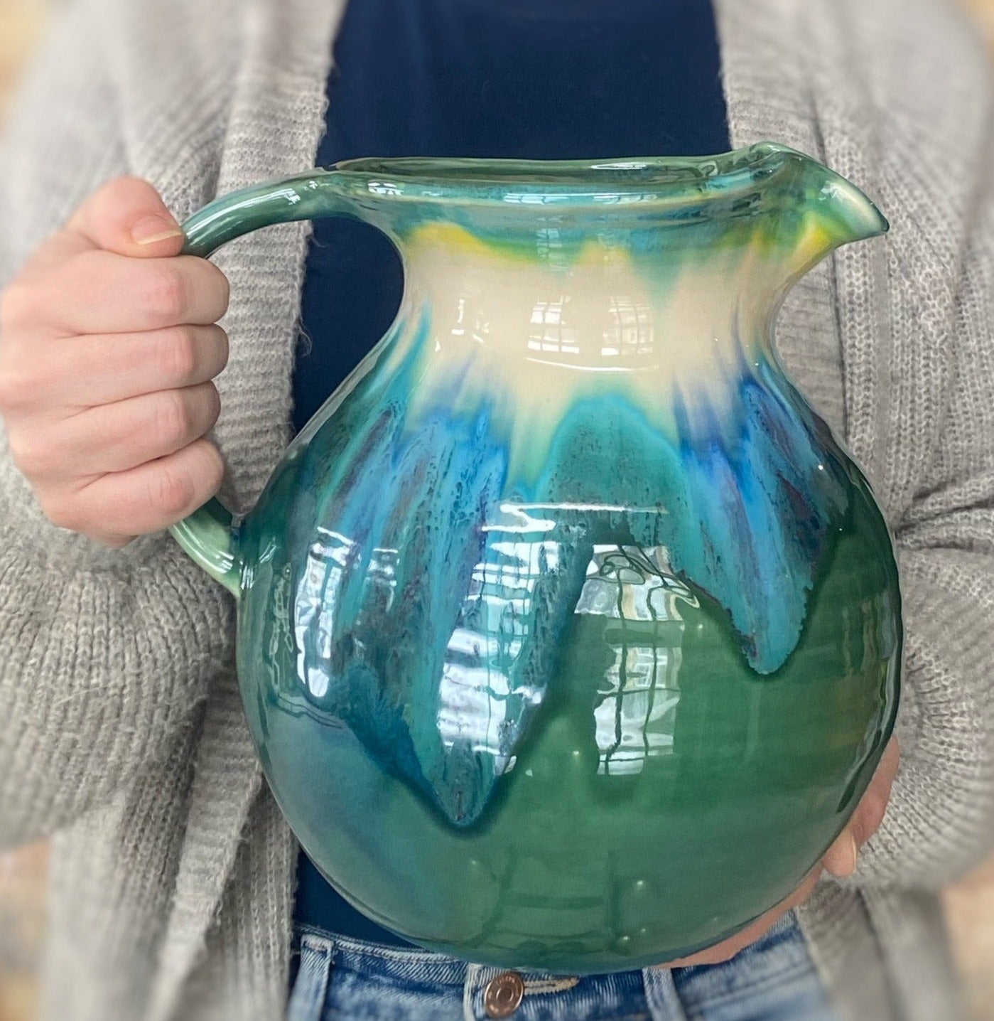 Large Teal Pitcher in a person's hands
