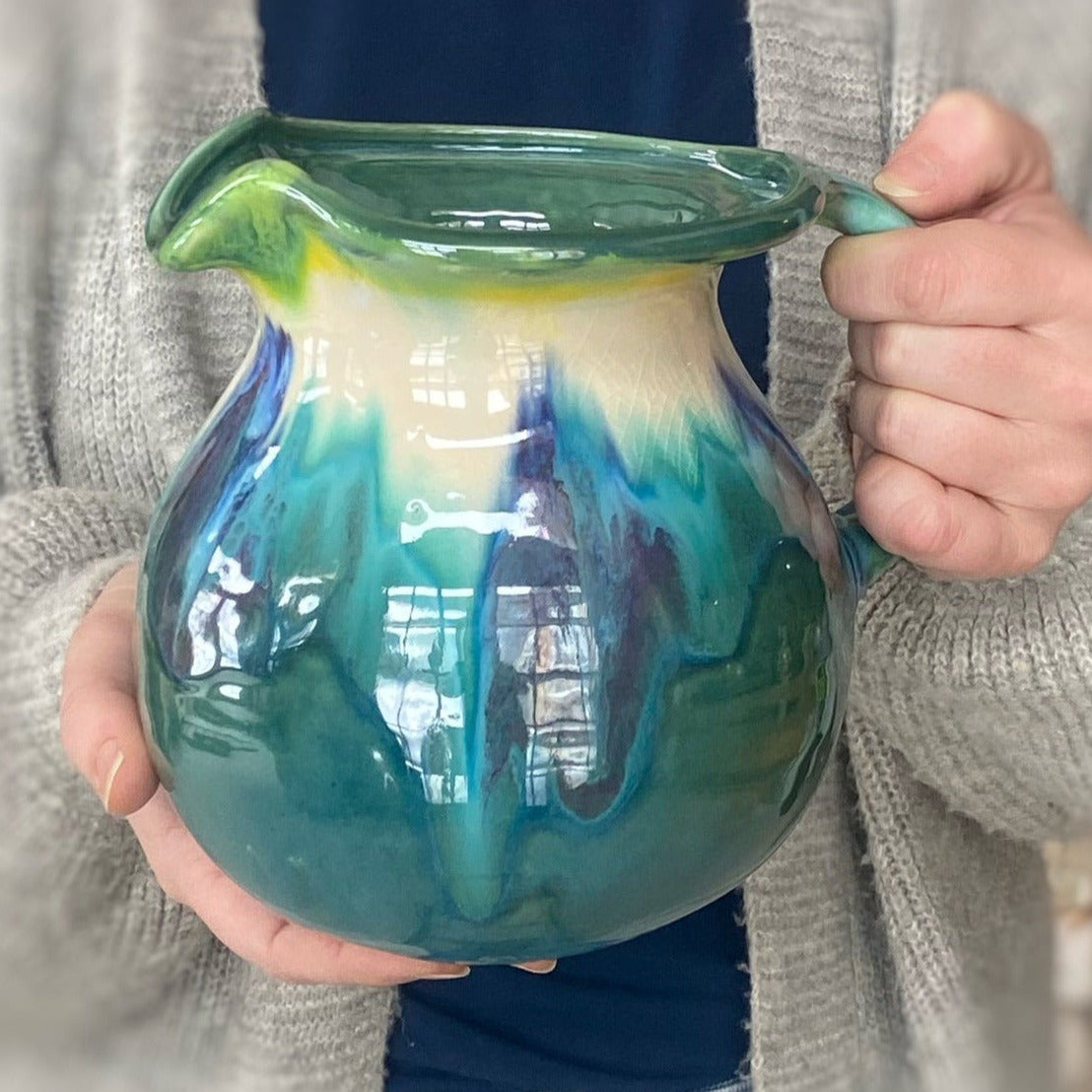 Small Teal Pitcher in a person's hands